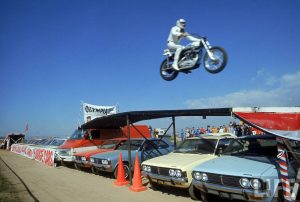 Marilyn Stemp helped get the Evil Knievel museum together. She knows everyone in the industry and helped to put the pieces together. Once Pat finds out that Marilyn has a direct line on t-shirts, he wheedles a Knievel t-shirt from Stemp. She talks about Knievel’s snake pit jump being recreated by Doug Danger at Buffalo Chip.